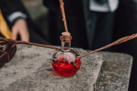 Mysterious red potion in a glass bottle with magic wands, invoking an enchanting alchemical atmosphere.